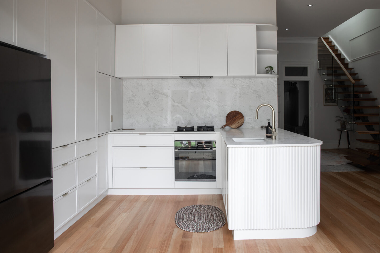 White kitchen renovation with marble splashback and island bench