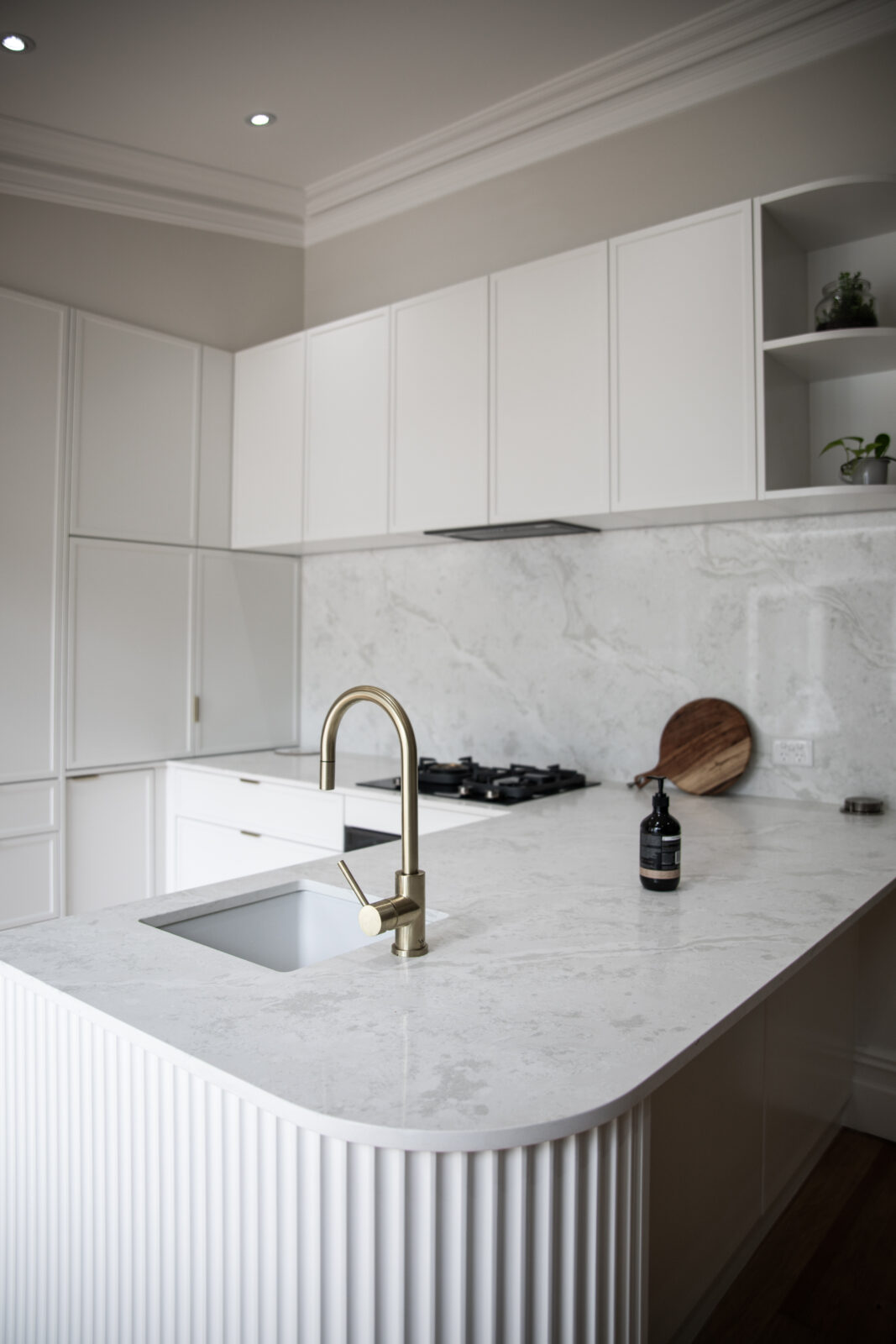 Modern kitchen with marble benchtop and brushed brass tapware