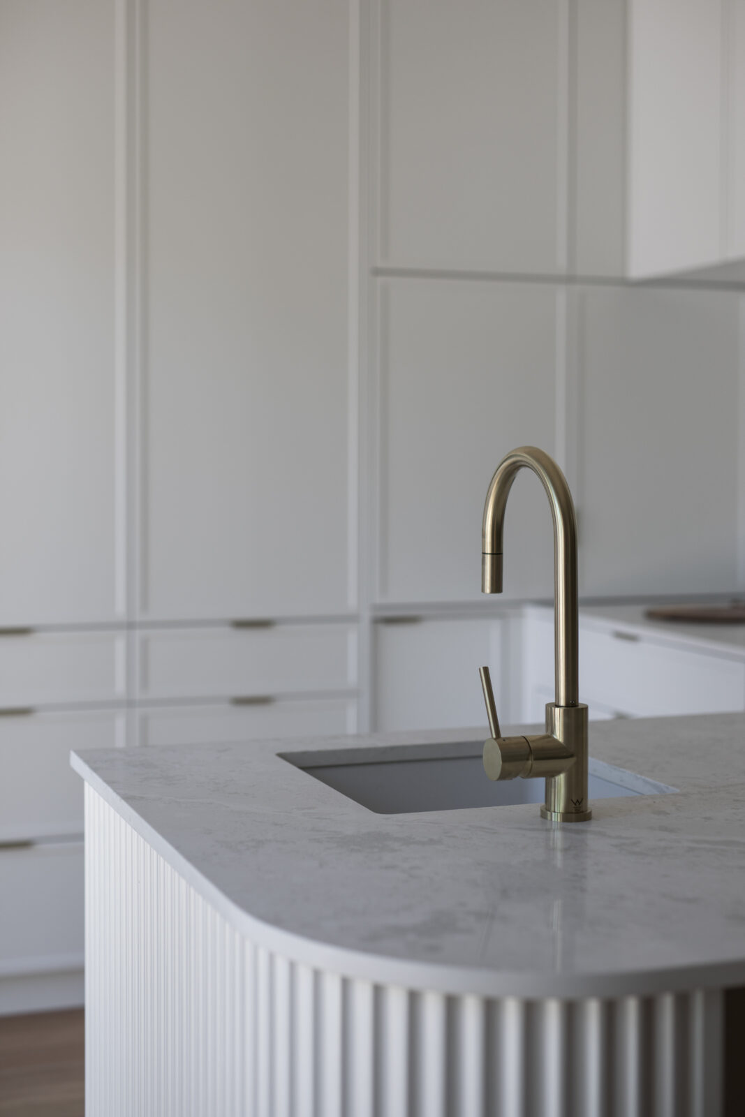 Brushed brass mixer tap on marble kitchen benchtop